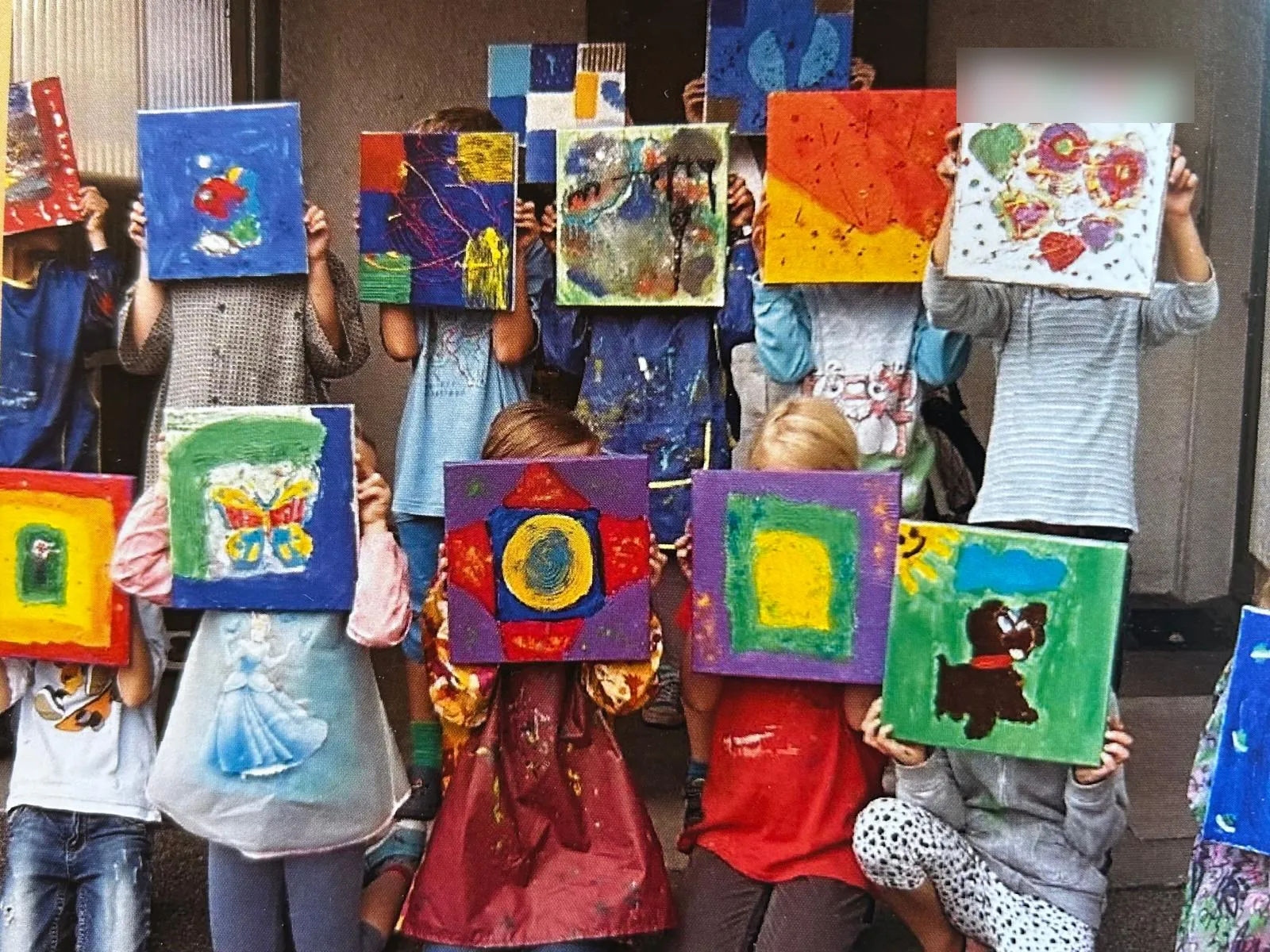 Kinder zeigen stolz ihre fertigen Leinwände
